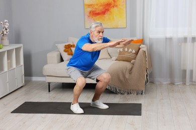 Photo of Elderly man exercising at home. Healthy leisure