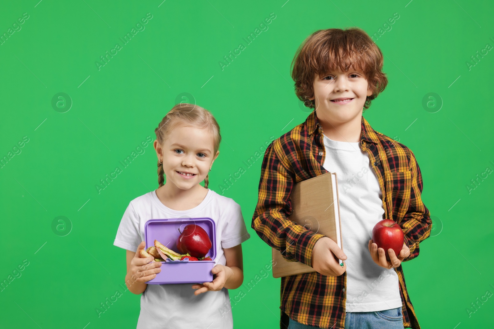 Photo of Cute little children with lunch on green background