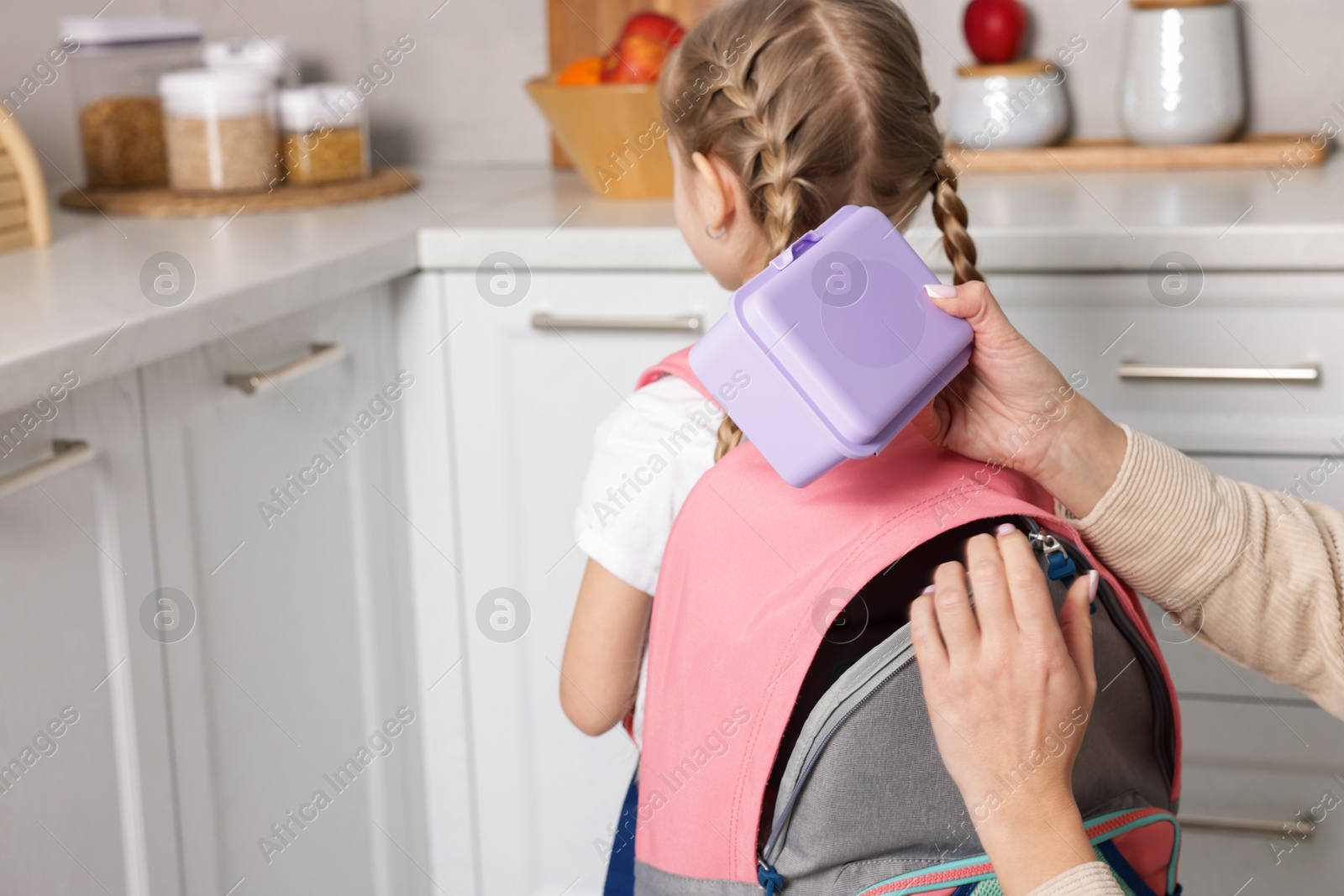 Photo of Mother packing her daughter's lunch in kitchen, closeup. Space for text