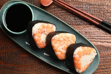 Photo of Tasty onigiri (Japanese rice balls) with shrimps served on wooden table, flat lay