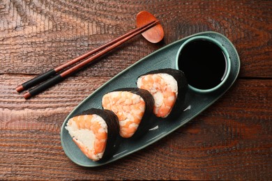 Photo of Tasty onigiri (Japanese rice balls) with shrimps served on wooden table, flat lay