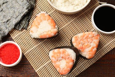 Photo of Tasty onigiri (Japanese rice balls) with shrimps served on wooden table, flat lay