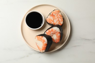 Photo of Tasty onigiri (Japanese rice balls) with shrimps and soy sauce on white marble table, top view