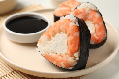 Photo of Tasty onigiri (Japanese rice balls) with shrimps and soy sauce on table, closeup