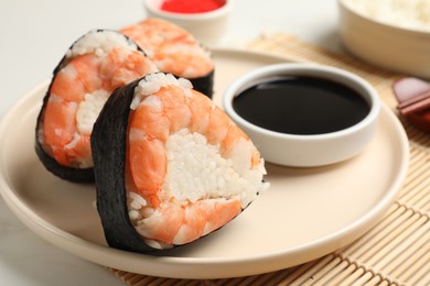 Photo of Tasty onigiri (Japanese rice balls) with shrimps served on table, closeup