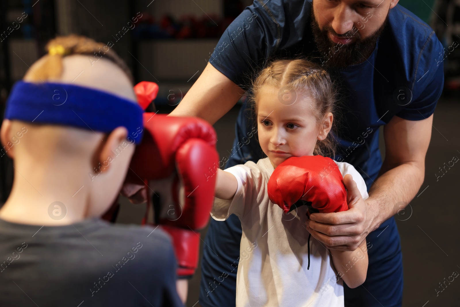 Photo of Children having boxing practice with their coach in training center