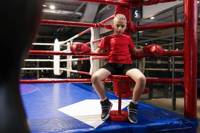 Boy sitting in his corner of boxing ring