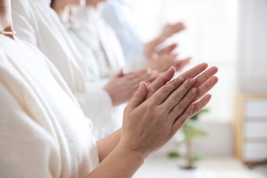 People applauding during meeting indoors, closeup view