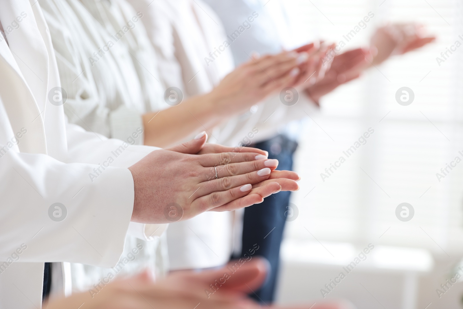 Photo of People applauding during meeting indoors, closeup view