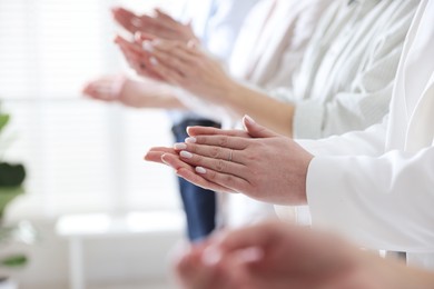 People applauding during meeting indoors, closeup view