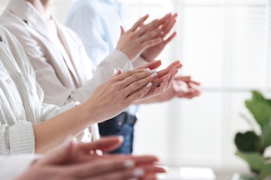 Photo of People applauding during meeting indoors, closeup view