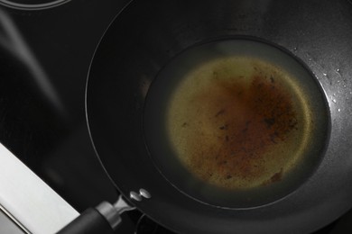 Photo of Used cooking oil in frying pan on stove, closeup