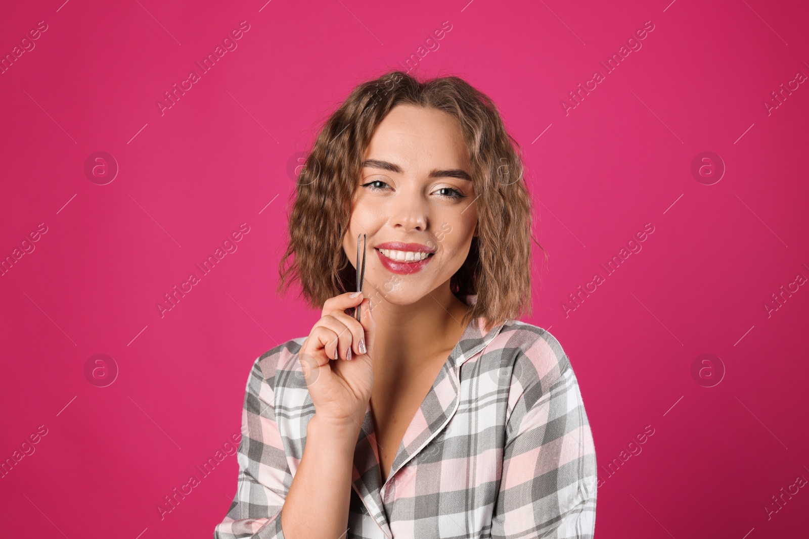 Photo of Happy woman with tweezers on pink background. Mustache removal tool