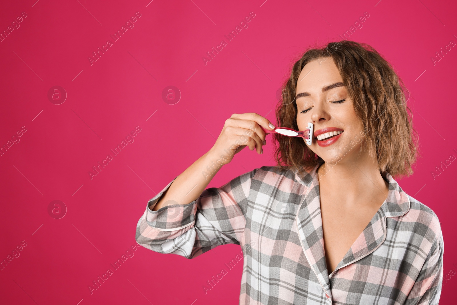 Photo of Happy woman shaving her mustache with razor on pink background. Space for text