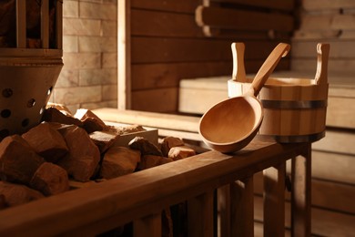 Bucket, ladle and stove with hot rocks in sauna