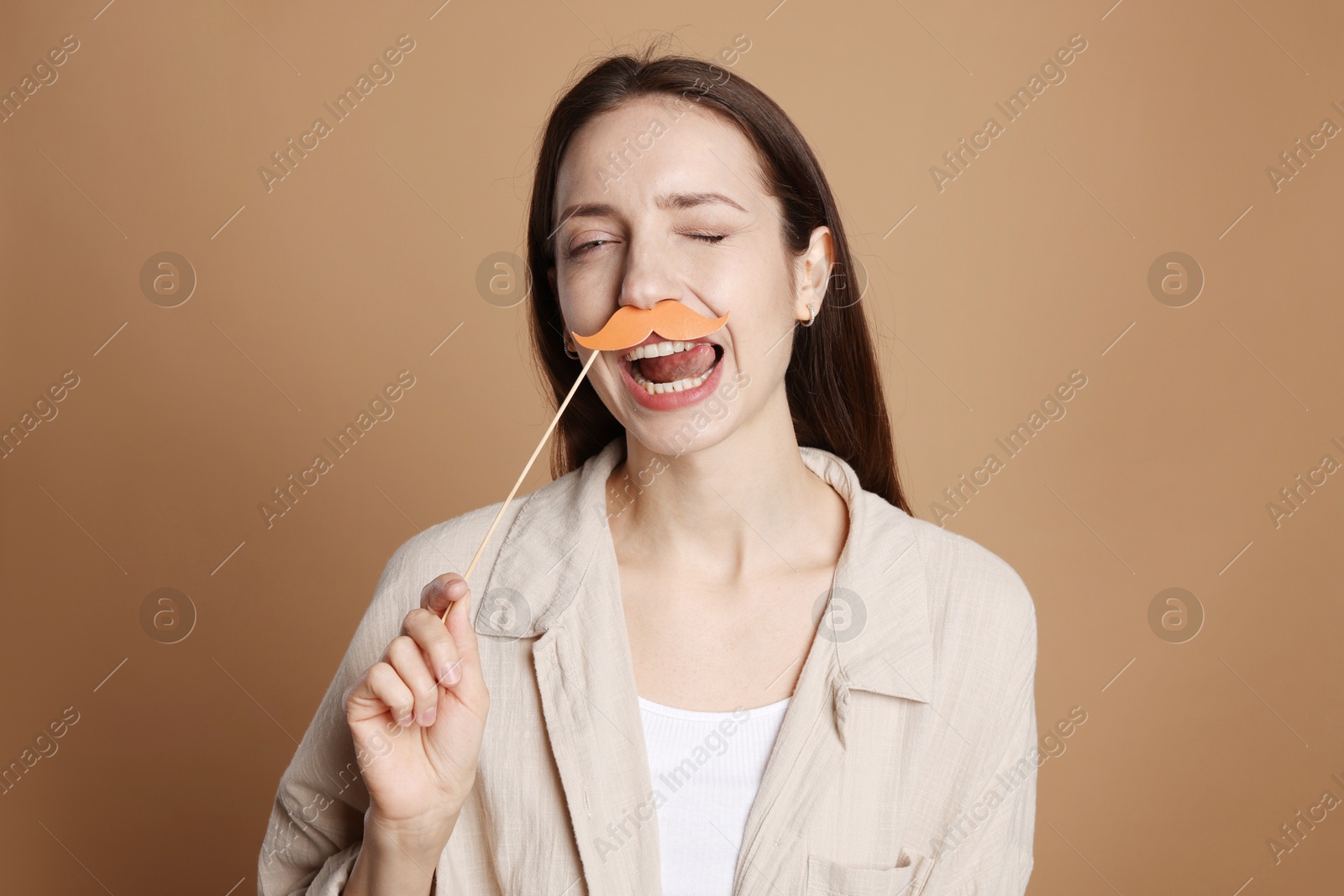 Photo of Funny woman with fake paper mustache on brown background