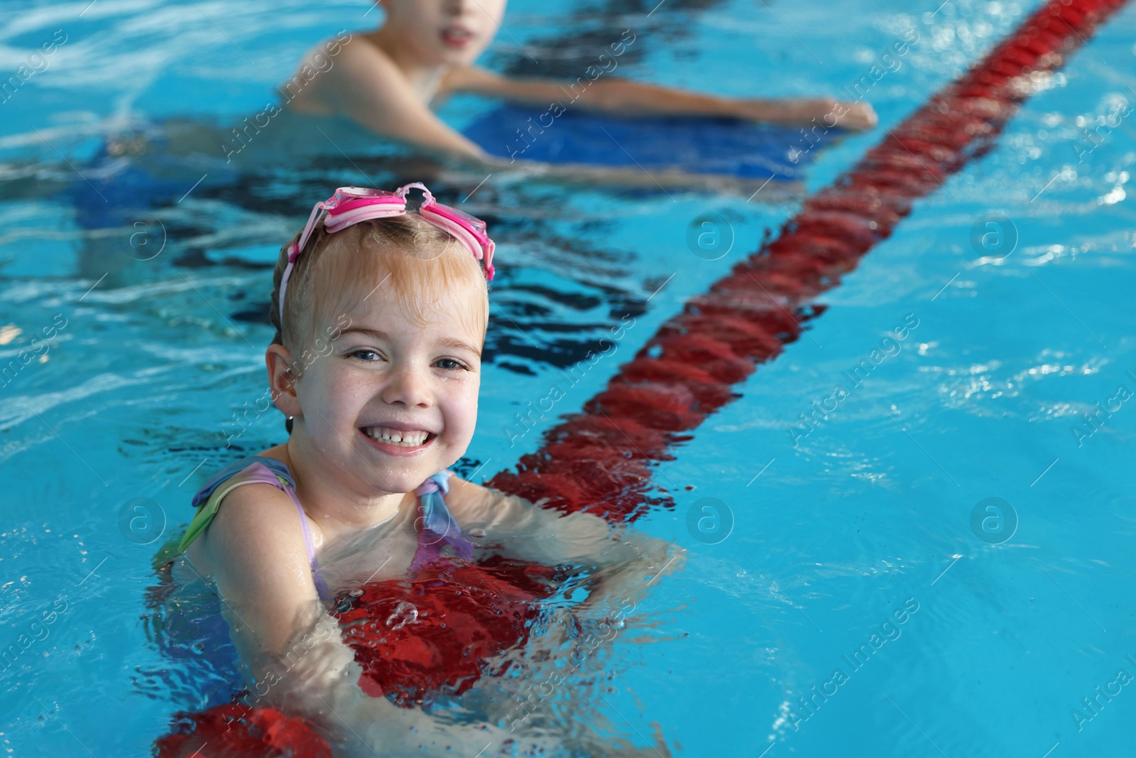 Photo of Children with goggles swimming in pool indoors, selective focus. Space for text