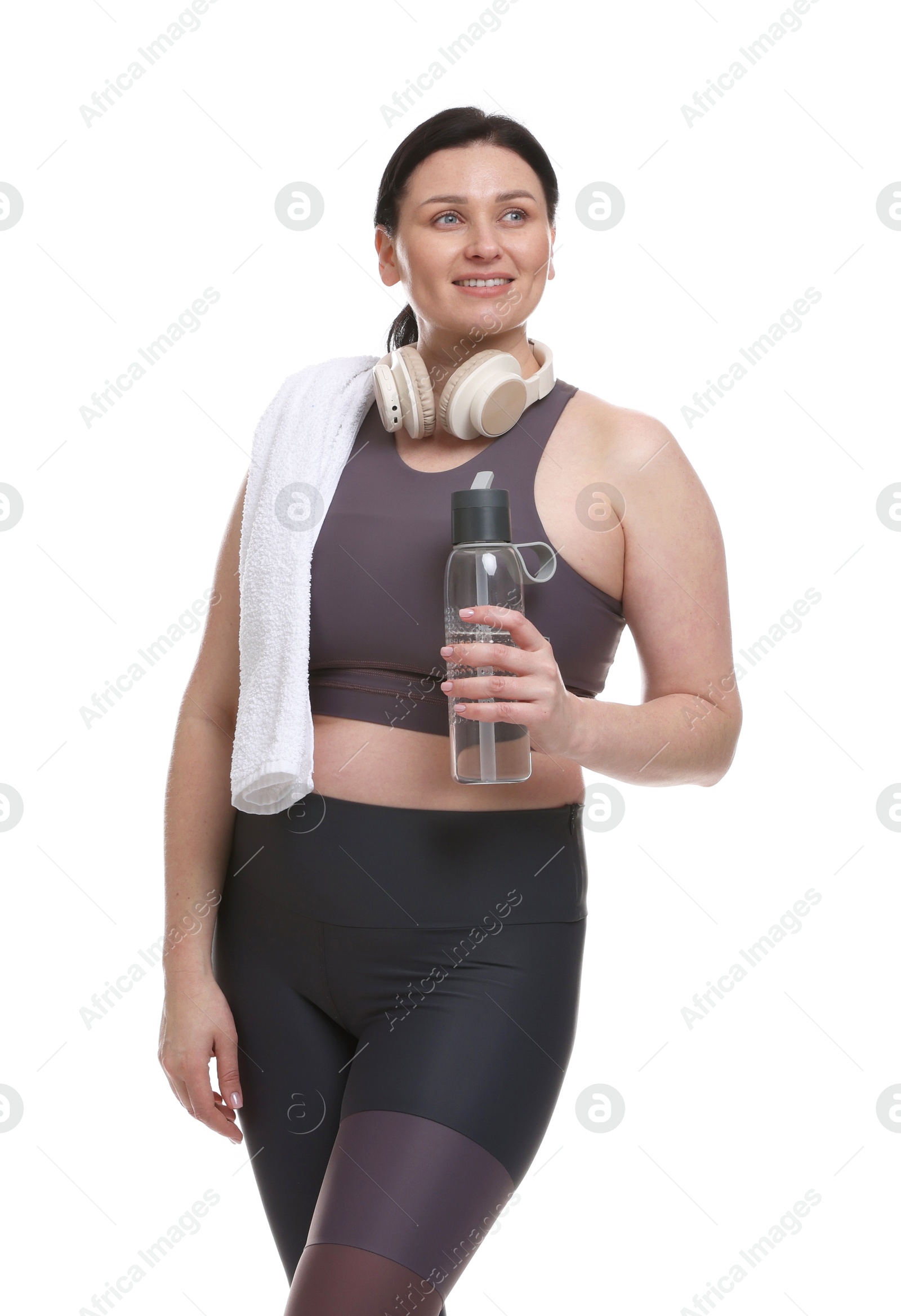 Photo of Plus size woman in gym clothes with water bottle, headphones and towel on white background