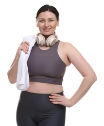 Plus size woman in gym clothes with headphones and towel on white background