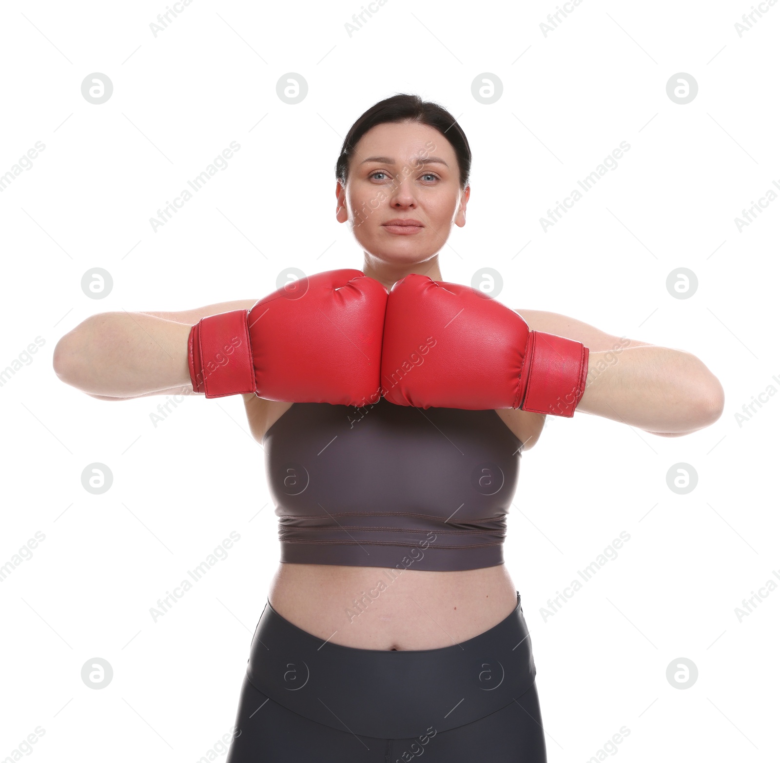 Photo of Plus size woman in gym clothes and boxing gloves on white background