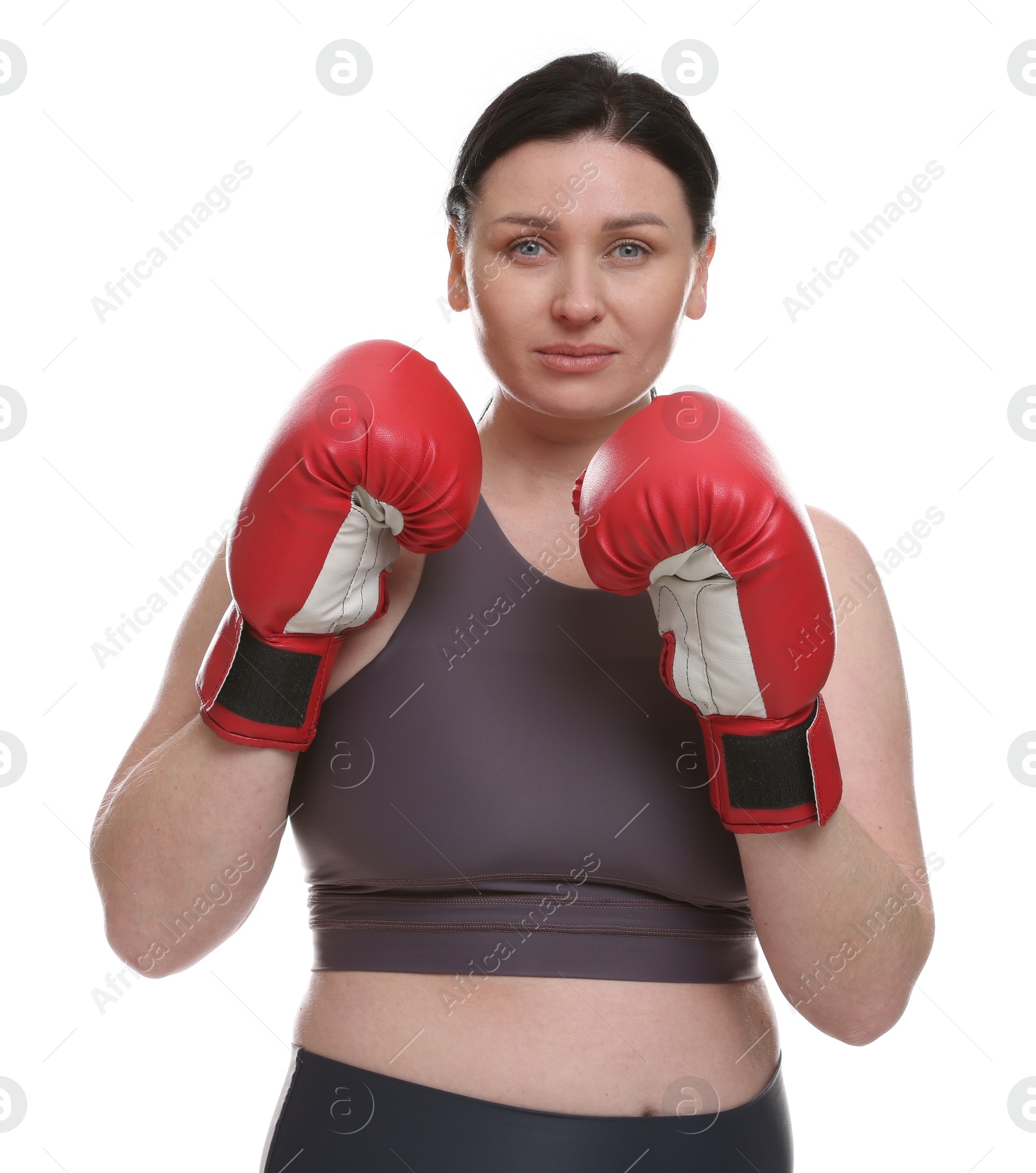 Photo of Plus size woman in gym clothes and boxing gloves on white background