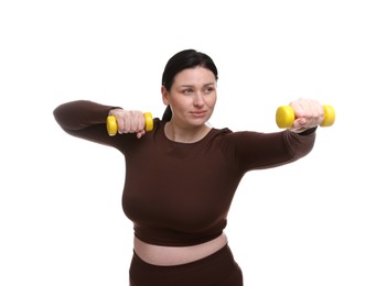 Plus size woman in gym clothes doing exercise with dumbbells on white background