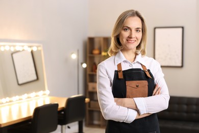 Photo of Portrait of smiling hairdresser in beauty salon, space for text