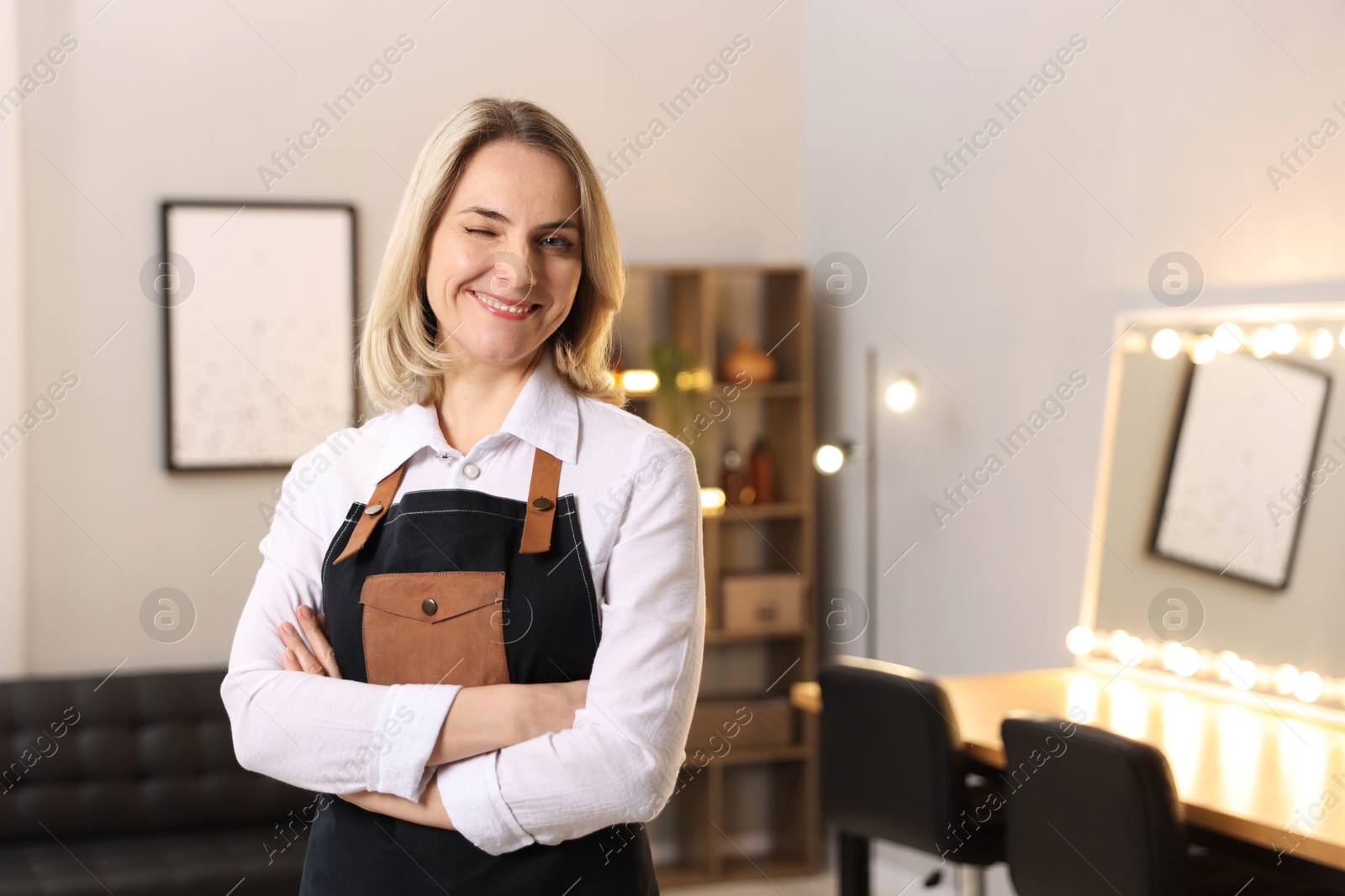 Photo of Portrait of smiling hairdresser in beauty salon, space for text