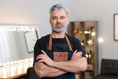 Portrait of hairdresser wearing apron in beauty salon