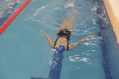 Photo of Woman swimming under water in indoor pool