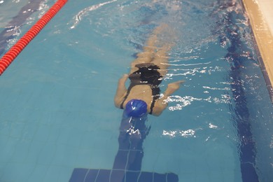 Woman swimming under water in indoor pool