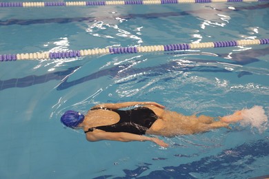 Woman wearing swimsuit swimming in indoor pool