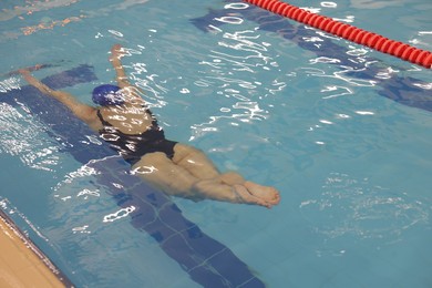 Woman swimming under water in indoor pool