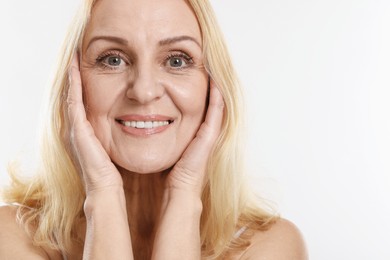 Portrait of smiling middle aged woman on white background. Space for text