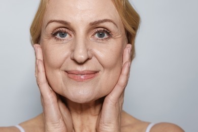 Portrait of beautiful middle aged woman on grey background