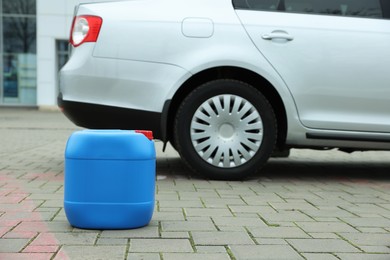 Photo of Light blue plastic canister on pavement outdoors