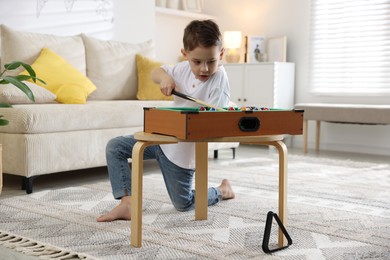 Cute little boy playing billiards at home