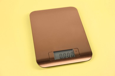 Photo of One electronic kitchen scale on yellow background