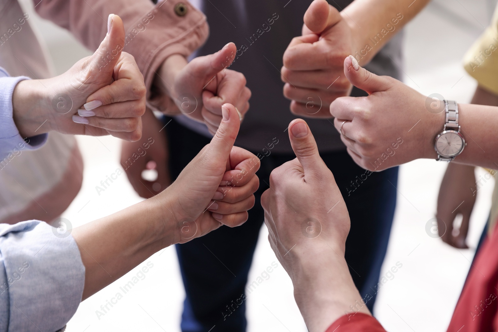 Photo of Unity concept. People showing thumbs up indoors, closeup