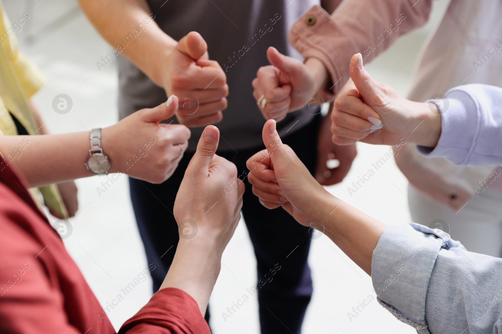 Photo of Unity concept. People showing thumbs up indoors, closeup