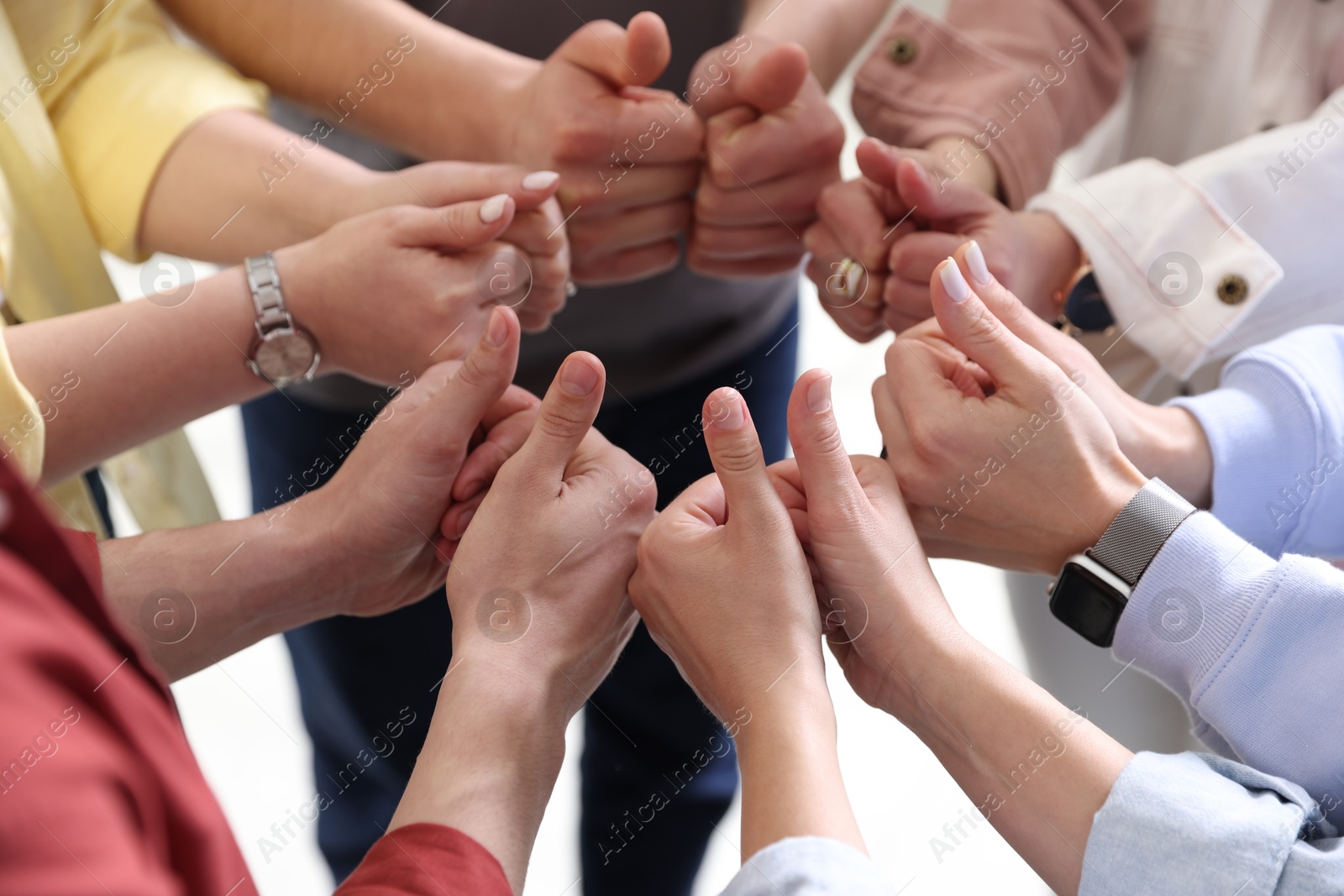 Photo of Unity concept. People showing thumbs up indoors, closeup