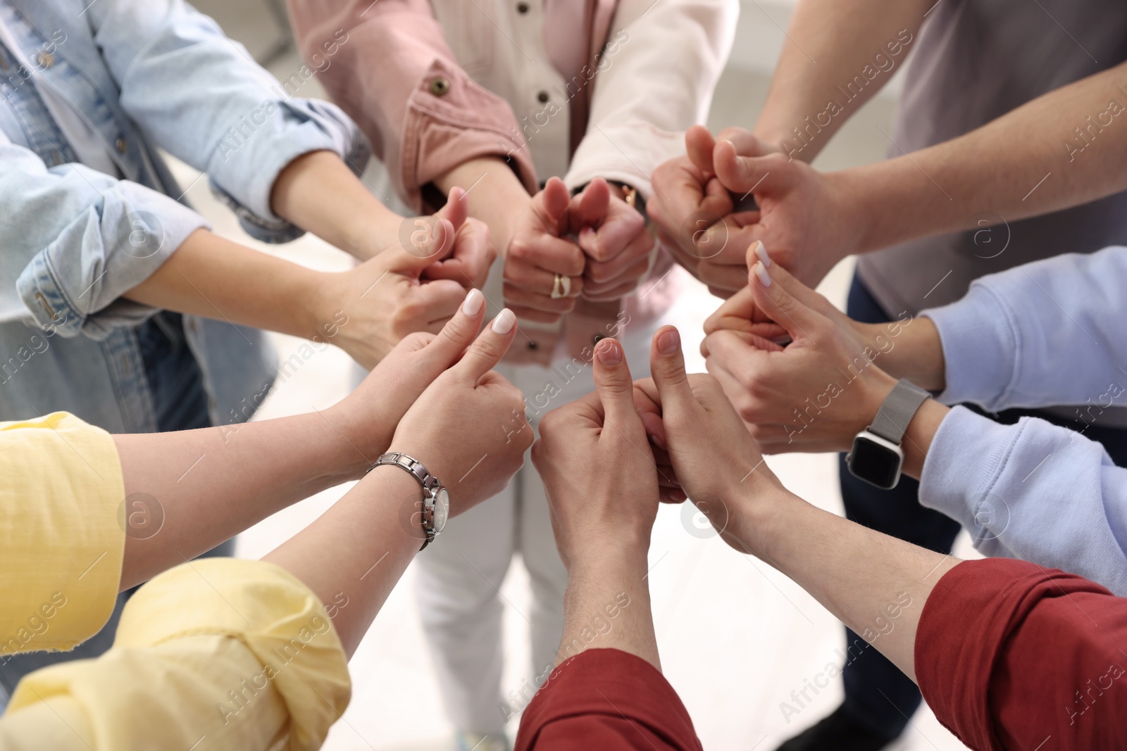 Photo of Unity concept. People showing thumbs up indoors, closeup