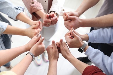 Photo of Unity concept. People showing thumbs up indoors, closeup