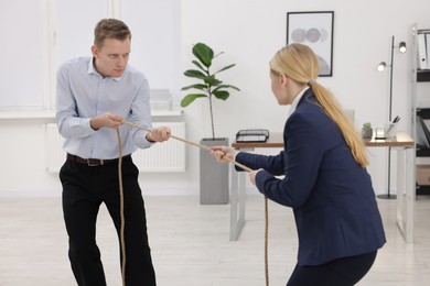 Photo of Competition concept. Businesspeople pulling rope in office