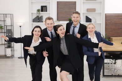 Competition concept. Group of happy businesspeople running in office