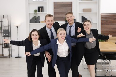 Competition concept. Group of happy businesspeople running in office