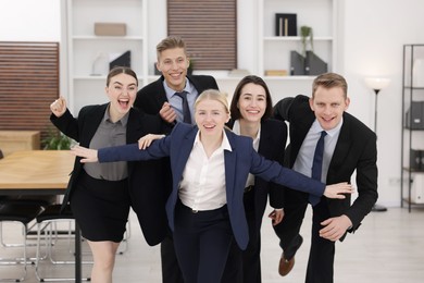 Competition concept. Group of happy businesspeople running in office