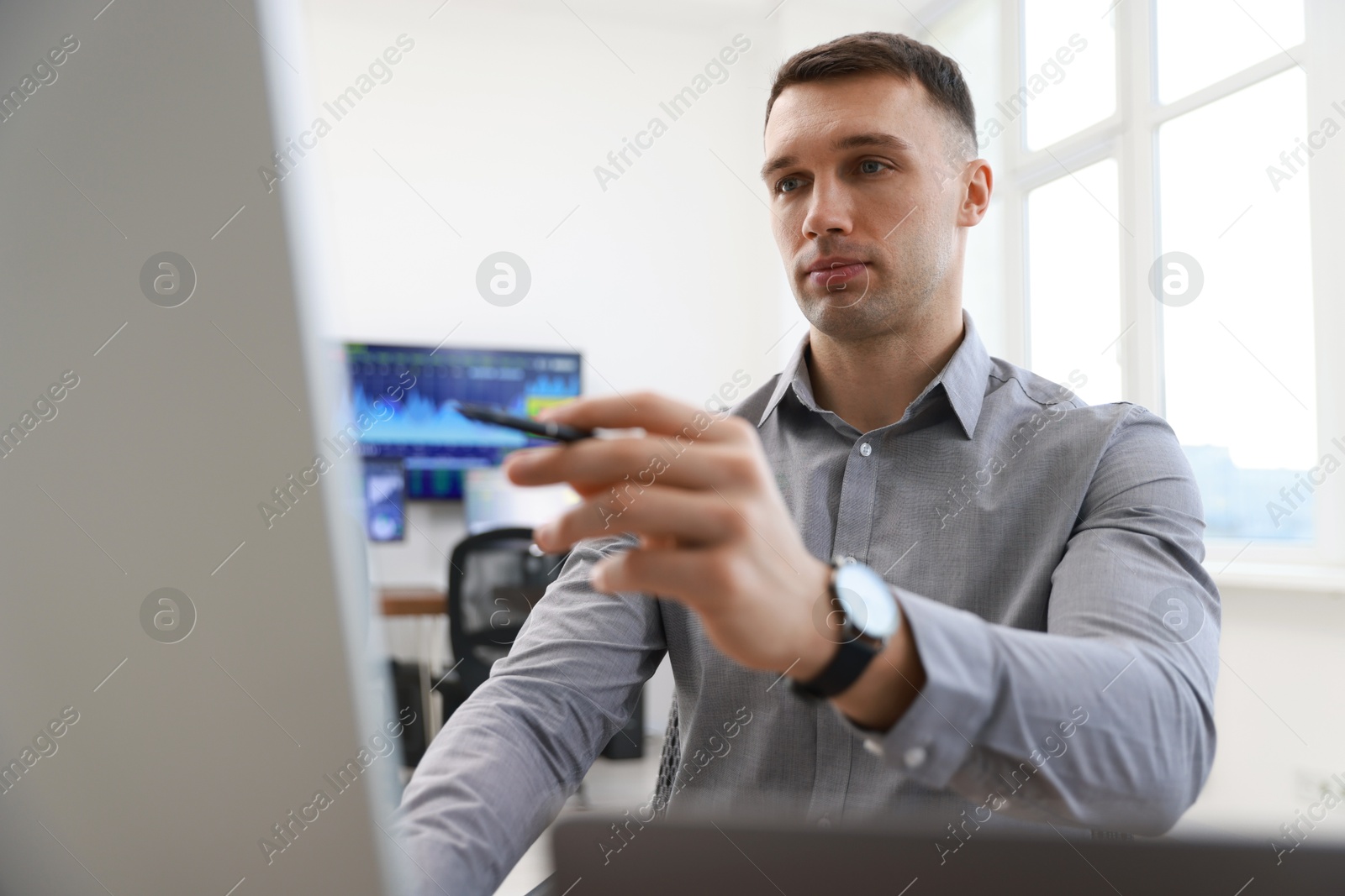 Photo of Financial trading specialist working on computer in office