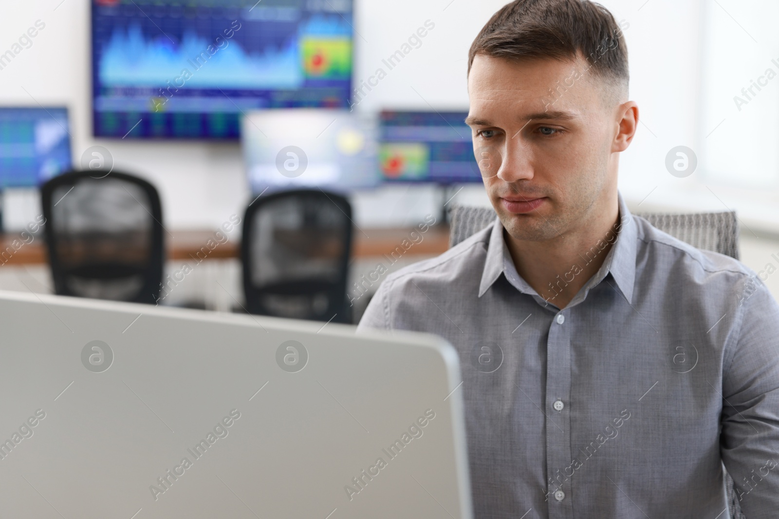 Photo of Financial trading specialist working on computer in office