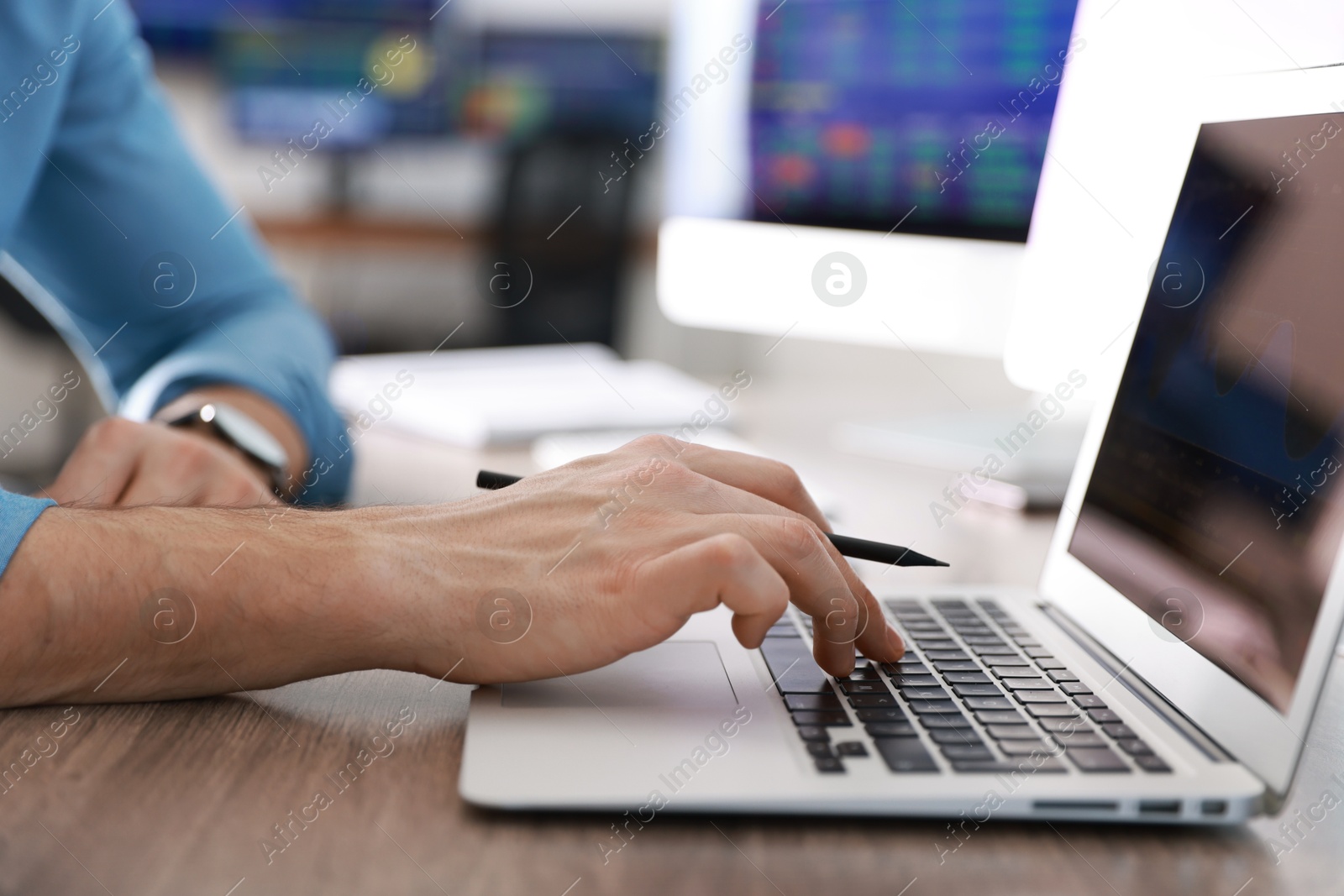 Photo of Financial trading specialist working on laptop at table in office, closeup